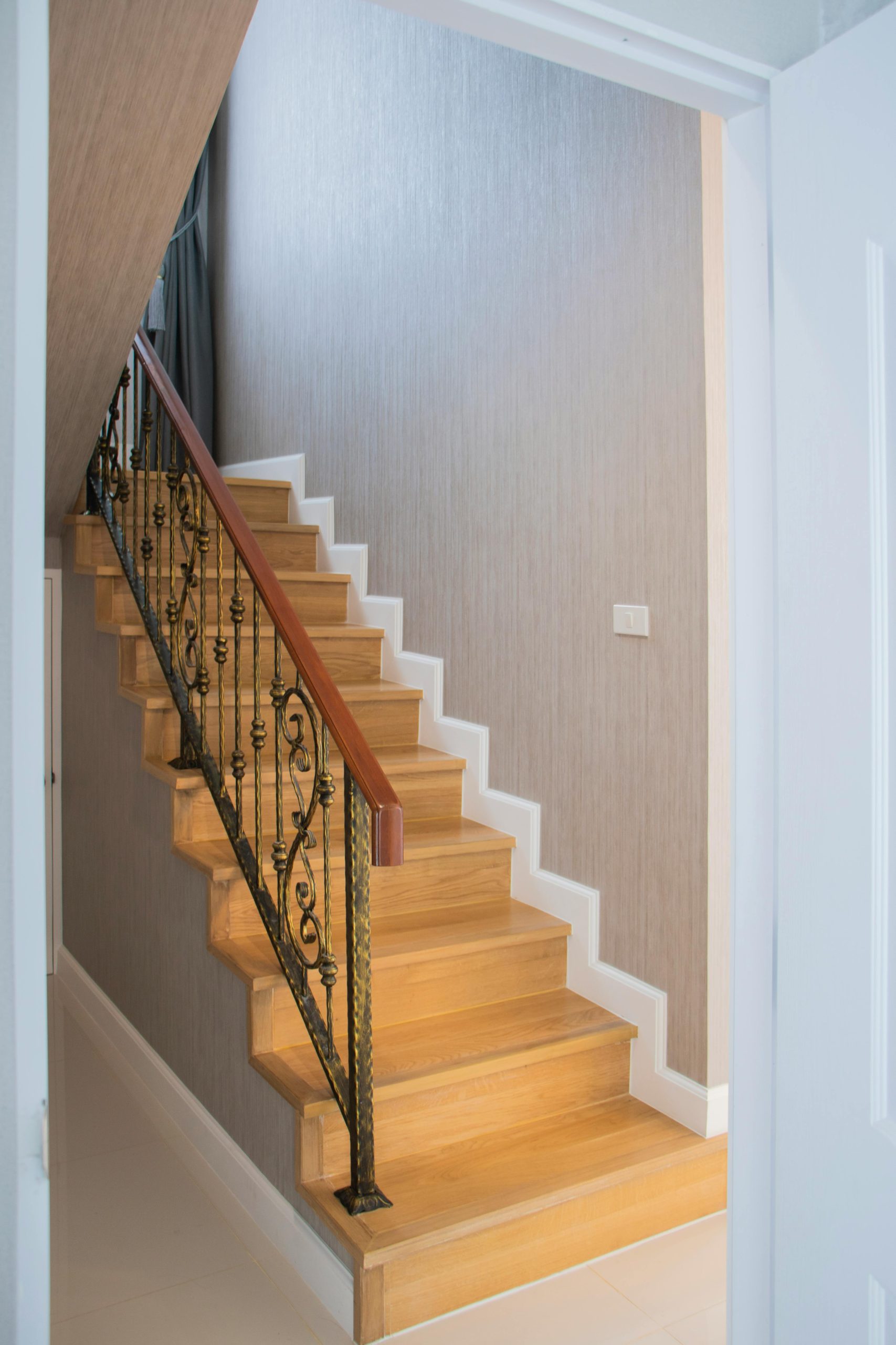 Escaliers en bois élégants avec une rampe en fer ouvragé dans un intérieur moderne.