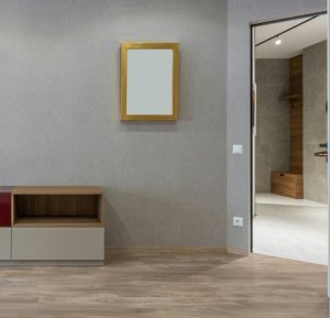 Spacieuse pièce contemporaine d'appartement neuf avec des étagères vides et un miroir rectangulaire sur des murs gris