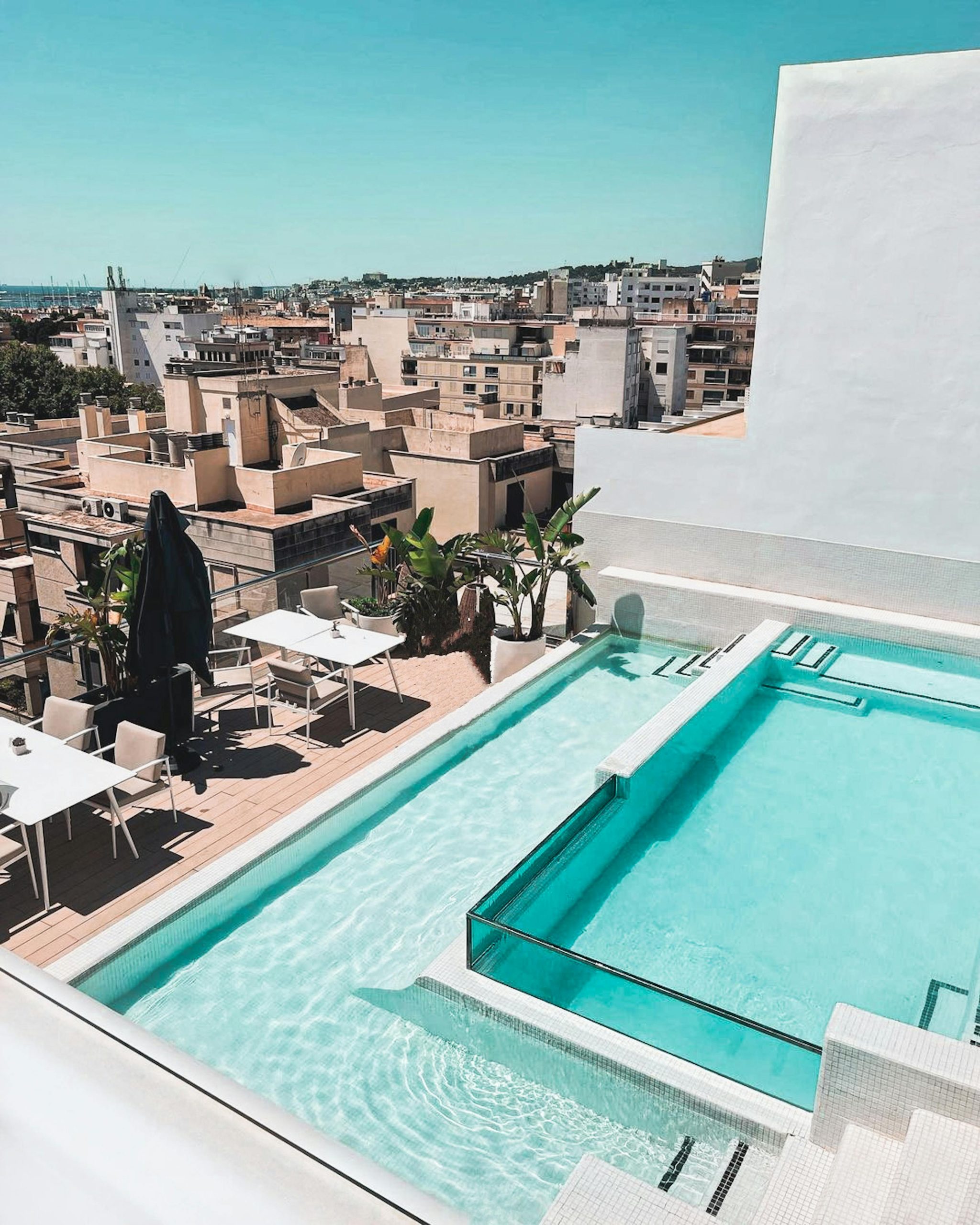 Une magnifique terrasse sur toit avec une piscine offrant une vue sur la skyline d'une ville, idéale pour la détente.