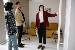 Realtor guidant des acheteurs potentiels lors de la visite d'un appartement élégant.